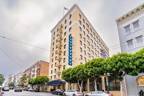 A tall hotel with a prominent sign, multiple floors, and a classic architectural style.