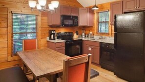 Enjoy cooking in this well-equipped kitchen with a central island, microwave, stove, and refrigerator.
