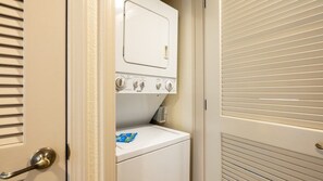 A laundry room with a washer and dryer, a door with a handle, and a window with blinds. - Angels Camp | Friends & Family Golf Getaway | Pool + Golf | 3BR Sleeps 8 (Angels Camp)
