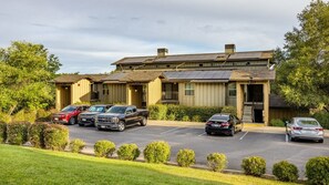Un hotel con varias unidades, estacionamiento y paneles solares en el techo.