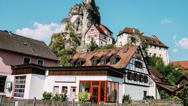 Un edificio tradicional europeo con un techo empinado, una fachada blanca destacada y una puerta roja.