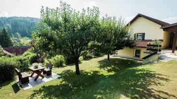 Relax in a serene outdoor space with a well-maintained lawn, a bench, and a small table.