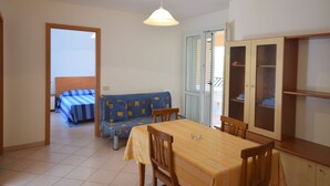 A compact living space with a dining table, chairs, a sofa, and a cabinet. - Lush Holiday Home in Sciacca near Golf Course (Sciacca)