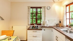 A small kitchen with a window, a kettle, a coffee maker, and a sink. - Nature Escape in Bohon (Durbuy)