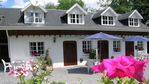 A white building with a sloped roof, multiple windows, and a gravel driveway. - Nature Escape in Bohon (Durbuy)