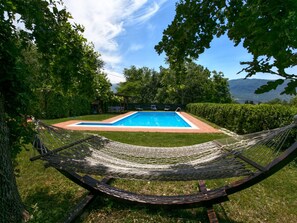 A hammock in a grassy area with a pool and a view of mountains in the background. - Mansion in San Valentino With Pool (San Valentino In Abruzzo)