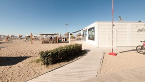A beachside area with a wooden walkway leading to a building with a sign that reads "MARINE". - Modern Apartment in Rimini With Balcony (Rimini)