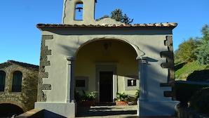 A small church with a bell tower, an arched entrance, and potted plants. - Farmhouse in Dicomano With Tuscan Views (Dicomano)