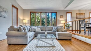 A modern living room with a sectional sofa, a glass coffee table, and a patterned rug. - Ultimate Stone Mountain I Cabin-Style I  Sleep 20 (Stone Mountain)