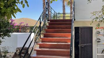 A staircase leading to a building with a white exterior and a black door.