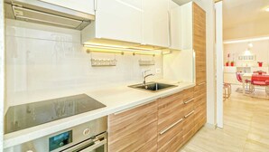 A modern kitchen with white cabinets, a stainless steel sink, and wooden drawers. - Modern Villa in Salakovci With Private Pool (Labin)