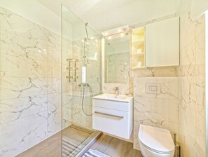 Enjoy a luxurious bathroom experience with a sleek shower, spacious vanity, and modern amenities.