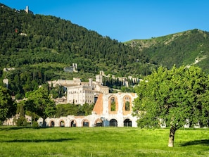 A historic town with medieval architecture, including a prominent castle and a church with a bell tower. - Holiday Home in Umbria Near Perugia (Gubbio)