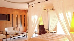 Een slaapkamer met een bed, nachtkastje en stoel.