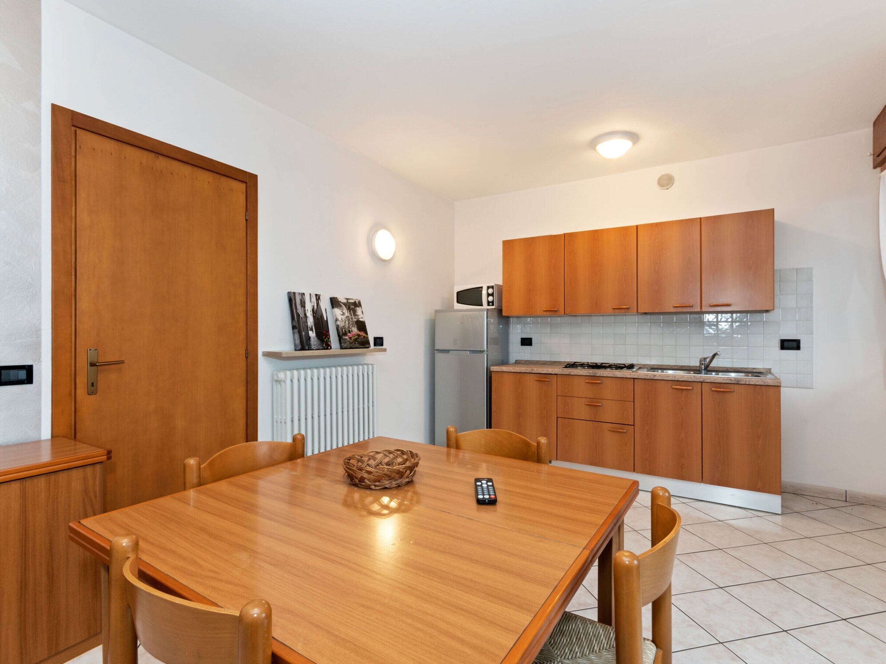 A compact kitchen with wooden cabinets, a microwave, and a gas stove.