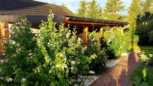 Ein Garten mit einem Ziegelweg, der zu einer hölzernen Pergola führt.