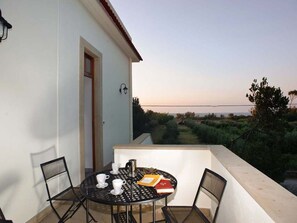 A balcony with a round table, chairs, and a view of the countryside. - Detached Villa in an Excellent Location Near the Sea (Patti)