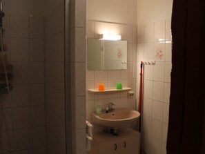 A bathroom with a shower, a sink, a mirror, and a towel rack. - Wohnung mit Garten in Klutz (Klütz)