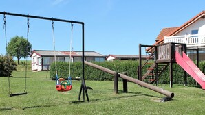 A playground with swings, a slide, and a climbing structure.
