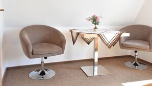 A small, modern room with two leather chairs, a small table with a vase of flowers, and a white wall. - Apartment in Pepelow for Zwei Personen (Am Salzhaff)