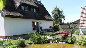 A thatched-roof house with a garden and a small pond. - Apartment in Pepelow for Zwei Personen (Am Salzhaff)