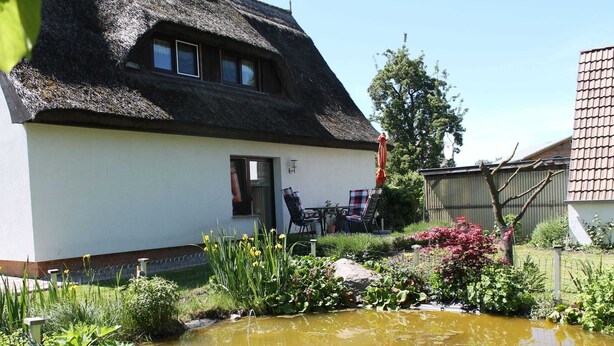 A thatched-roof house with a garden and a small pond. - Apartment in Pepelow for Zwei Personen (Am Salzhaff)