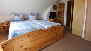 A bedroom with a wooden bed, a television, a cabinet, and a door. - Apartment in Pepelow for Zwei Personen (Am Salzhaff)