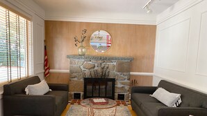 A living room with two sofas, a stone fireplace, a coffee table, and a rug. - 🌲🚣‍♂️🦅 Spacious Lake Cottage MSTR Suite LRG Deck Lake Wallenpaupack (Greentown)