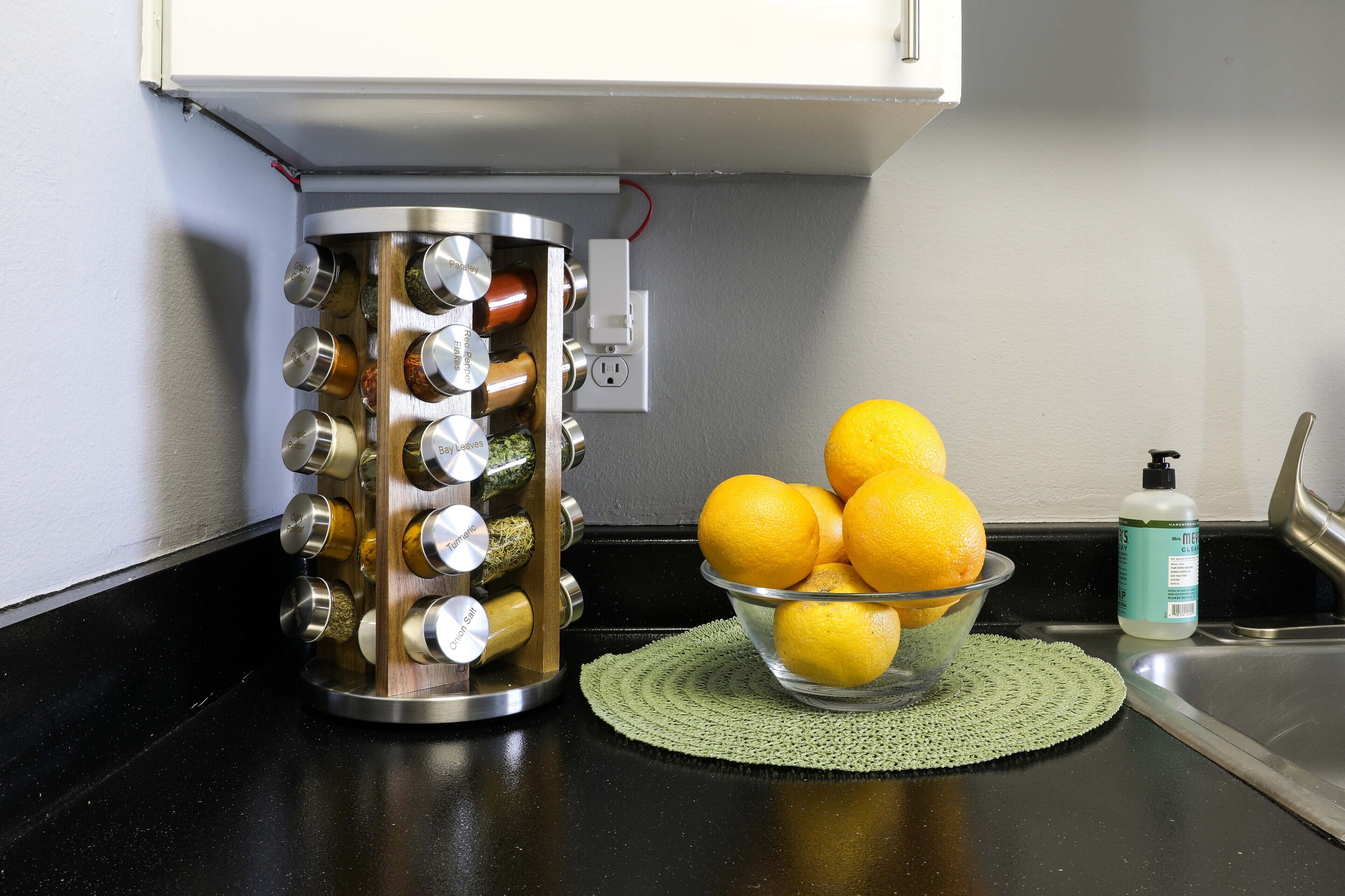 Un plan de travail de cuisine avec un presse-agrumes, un bol de citrons et une bouteille de liquide vaisselle.