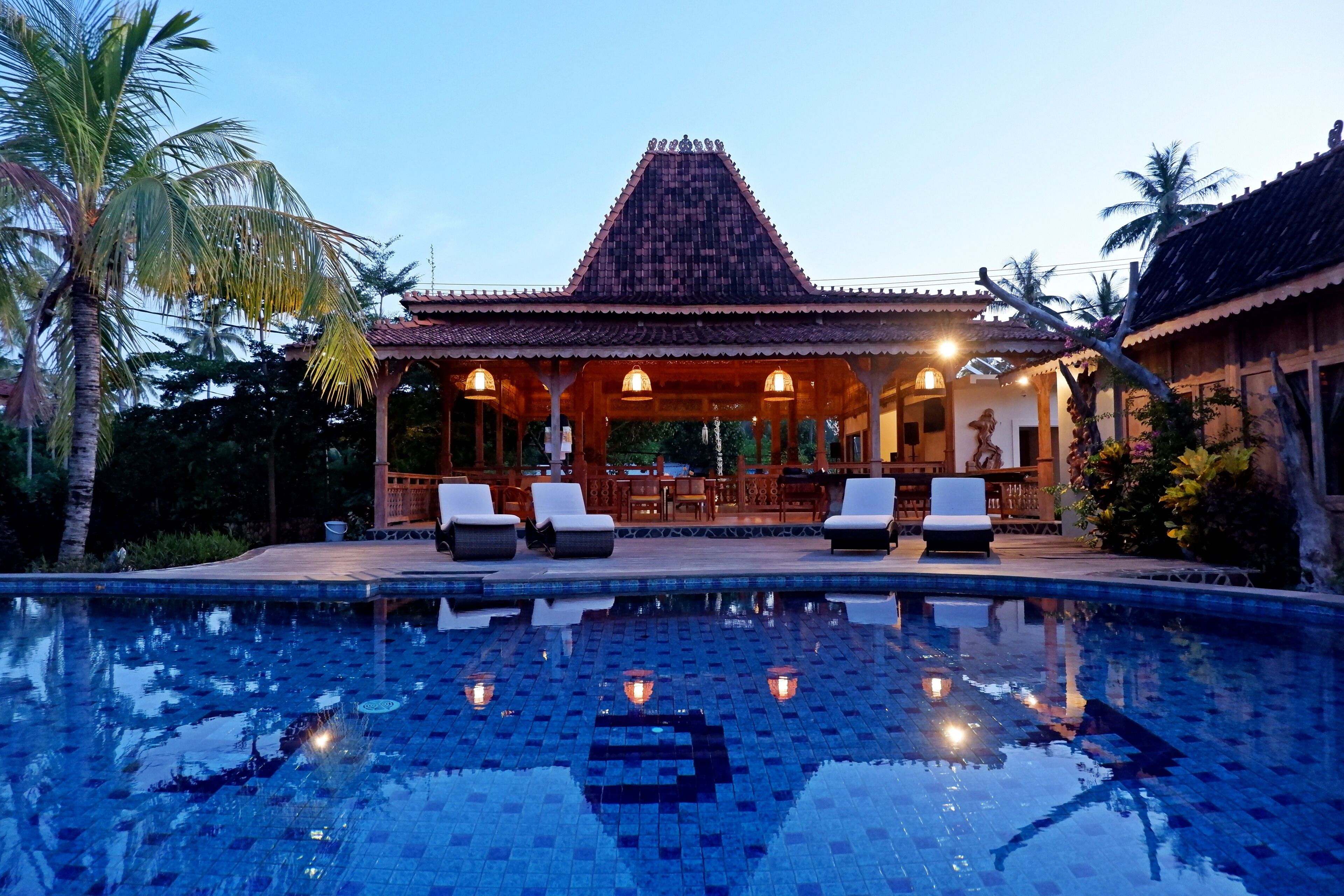 A traditional building with a tiled roof and a swimming pool in front.