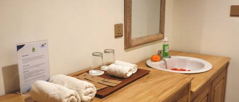 A bathroom with a wooden vanity, a sink, a mirror, and a towel rack.
