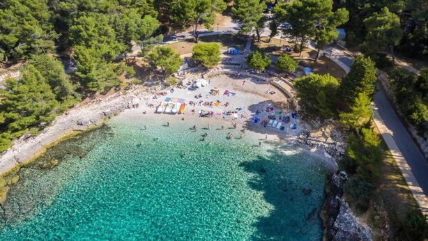 An aerial view of a beach with clear turquoise waters, surrounded by dense green trees. - Superb Apartment in Murter with Hot Tub (Murter-Kornati)
