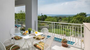 Un balcón con mesa y sillas, una piscina y vistas del paisaje.