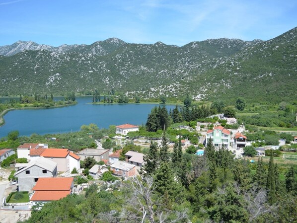 A lakeside village with buildings surrounded by mountains and trees. - Cozy Villa in Ploce With Shared Pool (Ploce)