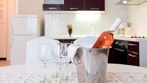 Ένα τραπέζι φαγητού με ένα μπουκάλι κρασί σε ένα μεταλλικό κουβά, περιτριγυρισμένο από άδεια ποτήρια κρασιού.