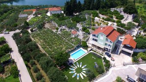 Ένα μεγάλο ακίνητο με πισίνα, πολλά κτίρια και μια λίμνη στο βάθος.
