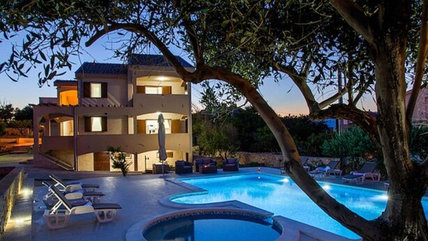 A two-story building with a swimming pool and lounge chairs. - Spacious Holiday Home With Swimming Pool (Razanac)