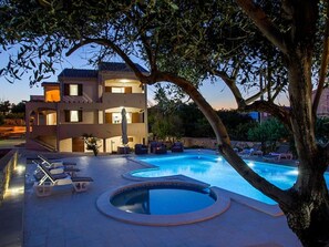 Un bâtiment à deux étages doté d’une piscine et de chaises longues.