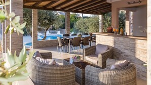 An outdoor patio with wicker furniture, a pool, and a bar area. - Spacious Holiday Home With Swimming Pool (Razanac)
