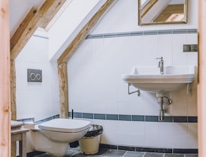 Ein Badezimmer mit Toilette, Waschbecken und Spiegel.