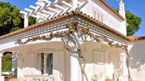 A white villa with a covered patio, white shutters, and a tiled roof. - Villa Near Marina With Private Pool (Loulé)