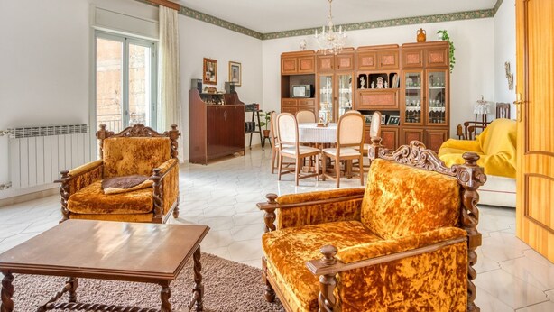 A spacious living room with a chandelier, a dining area, and a yellow sofa. - Posh Home in Santa Caterina Villarmosa near Nature Reserve (Santa Caterina Villarmosa)