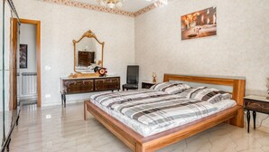 A bedroom with a large bed, a wooden headboard, a mirror, a dresser, and a chandelier. - Posh Home in Santa Caterina Villarmosa near Nature Reserve (Santa Caterina Villarmosa)