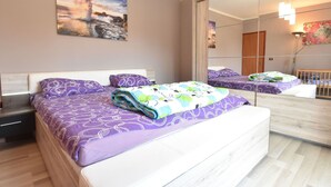 A bedroom with a large bed, a nightstand, a mirror, and a painting on the wall. - Premium Apartment in Barban With Private Pool (Barban)