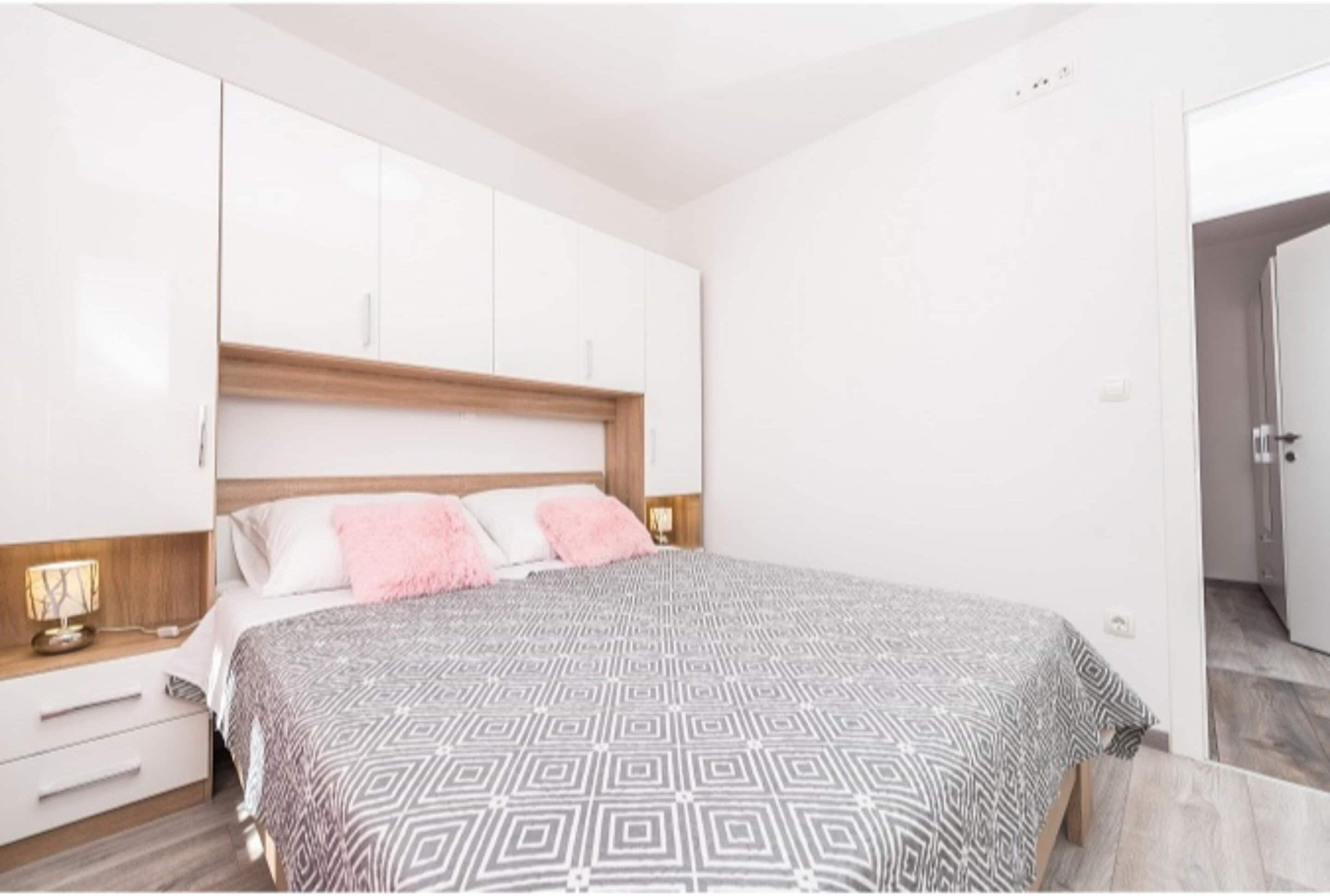 Un dormitorio con una cama, una mesita de noche y un armario.