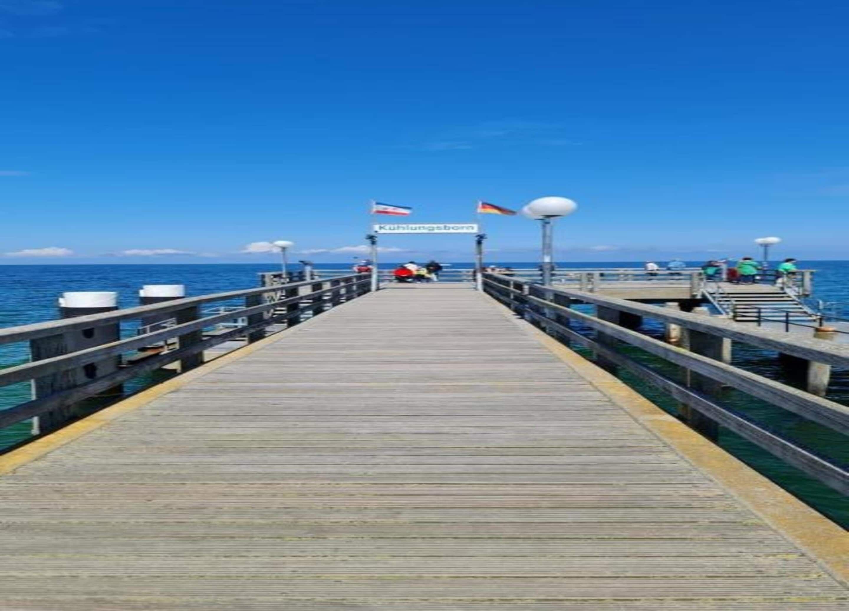 A wooden pier extending into the water with a sign reading "Kühlungsborn".