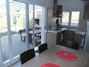 A compact kitchen with a dining area, large sliding glass doors, and a view of the outdoor patio. - Apartment in Dolac Near the Sea (Primosten)
