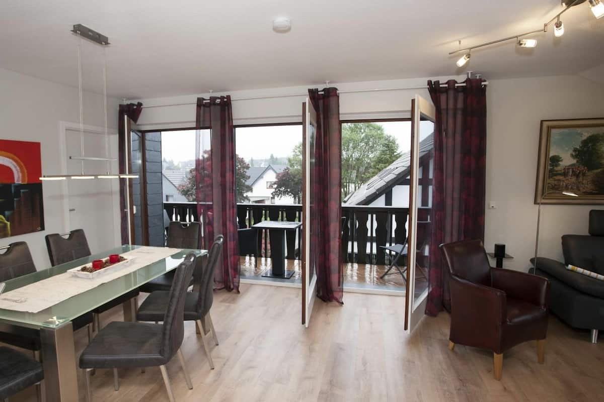 Ein geräumiges Zimmer mit Essbereich, einer Sitzecke und einem Balkon mit Blick auf die Nachbarschaft.
