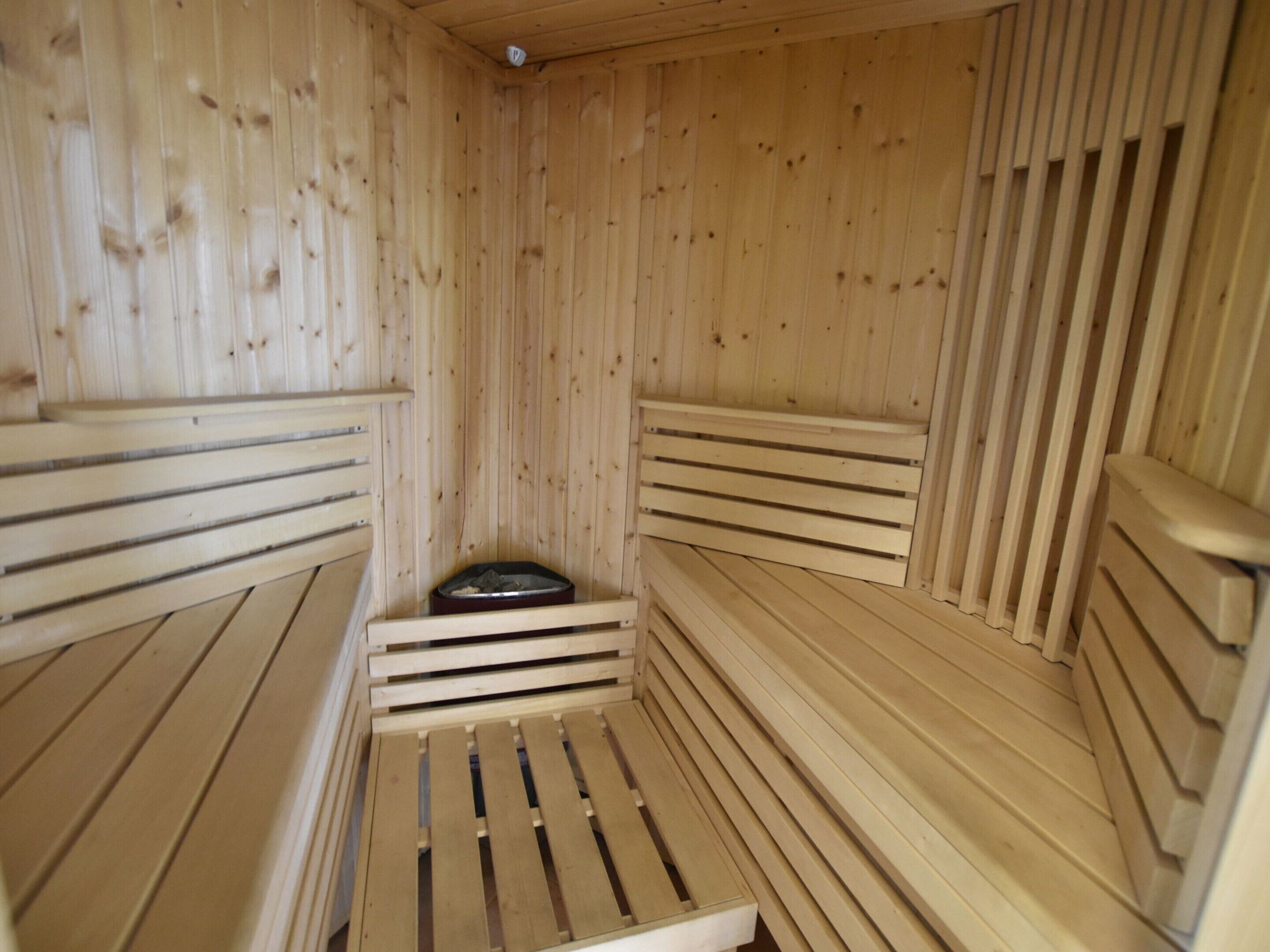 Een sauna met houten banken en een centrale verwarming.