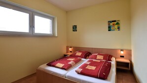 A bedroom with a bed, a window, and two wall-mounted nightstands. - Ferienwohnung in Zierow Nahe Meeresstrand (Zierow)